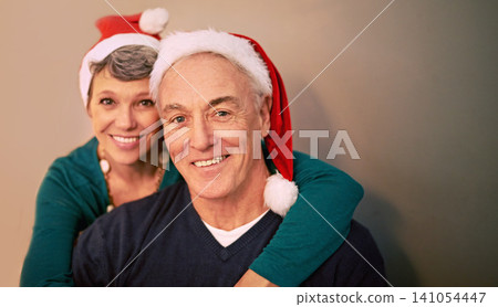 Christmas, portrait and senior couple with love, holiday and support together in home with romance. Happy, retirement and marriage with smile and hug in house with celebration and santa hat with joy Christmas, portrait and senior couple with love, holiday and support together in home with romance. Happy, retirement and marriage with smile and hug in house with celebration and santa hat with joy 141054447