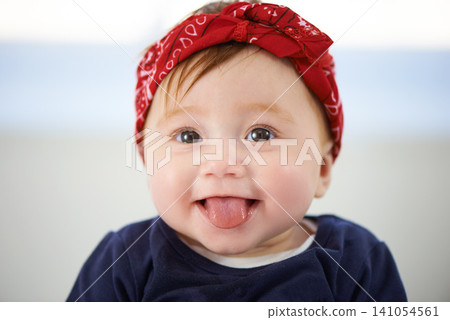 Portrait, tongue and cheerful baby fashion in family home, cute and trendy street style on curious girl toddler. Creative, child development and growth, adorable headband accessory on happy smile kid Portrait, tongue and cheerful baby fashion in family home, cute and trendy street style on curious girl toddler. Creative, child development and growth, adorable headband accessory on happy smile kid 141054561