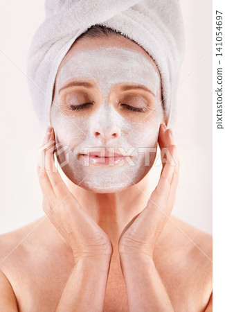 Face, mask or woman in studio for facial or skincare routine with natural detox or cosmetics with towel. Model, spa or female person with lotion for anti aging treatment or beauty on white background Face, mask or woman in studio for facial or skincare routine with natural detox or cosmetics with towel. Model, spa or female person with lotion for anti aging treatment or beauty on white background 141054697