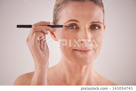 Beauty, portrait and woman with eyeliner in studio for makeup, natural and self care face routine. Cosmetics, smile and female person with cosmetology product for facial treatment by white background Beauty, portrait and woman with eyeliner in studio for makeup, natural and self care face routine. Cosmetics, smile and female person with cosmetology product for facial treatment by white background 141054743