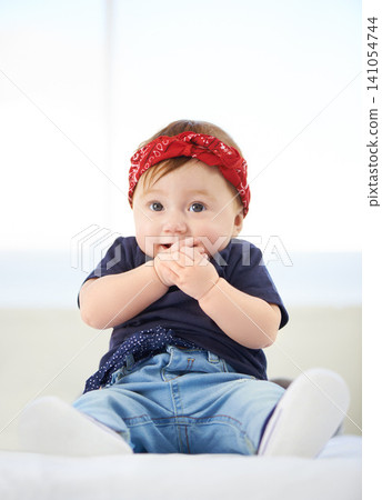Portrait, sitting and bed for baby fashion in family home, cute and trendy street style on curious girl toddler. Creative, child development and growth, adorable headband accessory with funky clothes Portrait, sitting and bed for baby fashion in family home, cute and trendy street style on curious girl toddler. Creative, child development and growth, adorable headband accessory with funky clothes 141054744