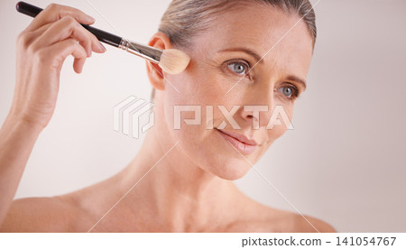 Makeup brush, beauty and face of woman in studio for cosmetic, self care or facial glow routine. Confident, foundation and mature female person with cosmetology tool for treatment by white background Makeup brush, beauty and face of woman in studio for cosmetic, self care or facial glow routine. Confident, foundation and mature female person with cosmetology tool for treatment by white background 141054767