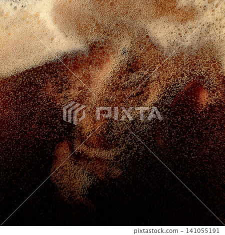 Dark beer foam with swirling bubbles and creamy head texture. 141055191