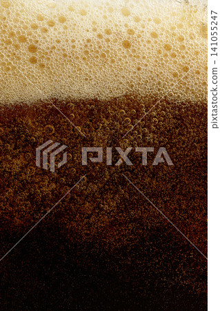 Dark carbonated soft drink with foamy top and sparkling bubbles. Dark carbonated soft drink with foamy top and sparkling bubbles. 141055247