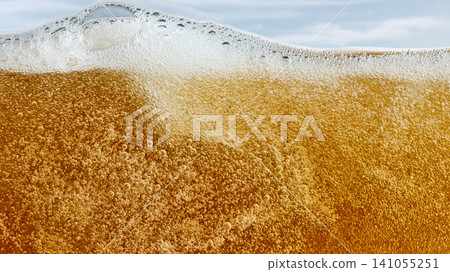 Foamy beer surface with golden carbonation and bubbles Foamy beer surface with golden carbonation and bubbles 141055251