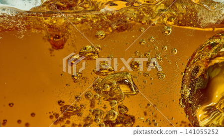 Beer glass macro with golden bubbles and foam line. Beer glass macro with golden bubbles and foam line. 141055252