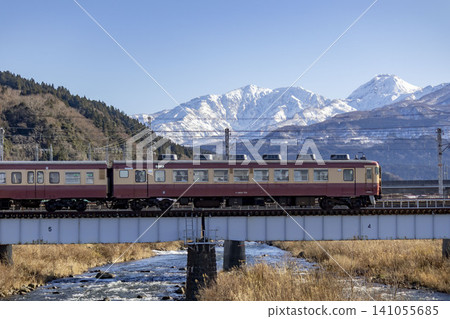 An express train on the Echigo Tokimeki Railway and a view of the mountain range. An express train on the Echigo Tokimeki Railway and a view of the mountain range. 141055685