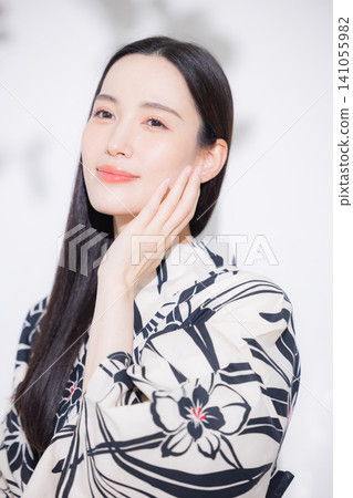 A woman in a yukata doing hair care. 141055982