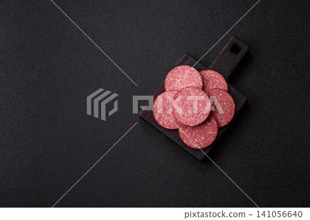 Slices of smoked salami or pepperoni for making sandwiches or pizza at home. Sausage slices Slices of smoked salami or pepperoni for making sandwiches or pizza at home. Sausage slices 141056640