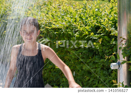 Teen girl showering under water at outdoor pool Teen girl showering under water at outdoor pool 141056827