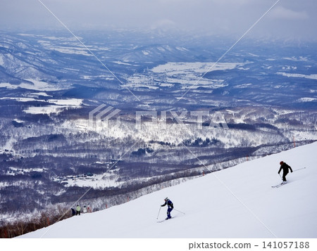 Skiers skiing down Wonderland at Niseko Village Ski Resort Skiers skiing down Wonderland at Niseko Village Ski Resort 141057188
