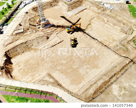 Aerial View Construction Site With Excavator and Crane Shadow Preparing Foundation and Earthworks Aerial View Construction Site With Excavator and Crane Shadow Preparing Foundation and Earthworks 141057340
