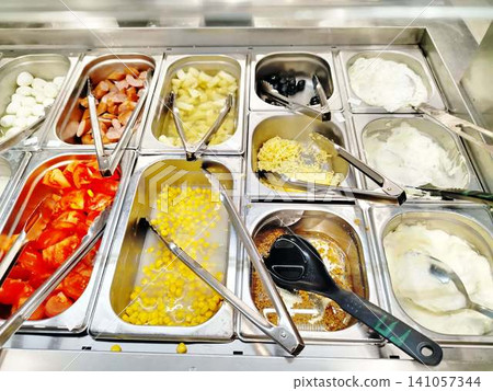 Self-Serve Salad Bar Counter With Fresh Toppings Corn Tomatoes Olives Yogurt And Sausage. 141057344