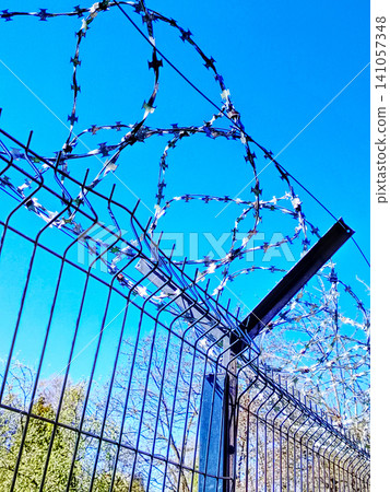 Razor Wire Fence and Security Barrier Against Clear Blue Sky Prison Perimeter Protection. Razor Wire Fence and Security Barrier Against Clear Blue Sky Prison Perimeter Protection. 141057348