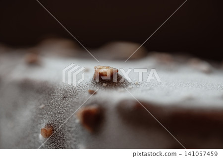Frozen chocolate bar with almond pieces and frost on its surface Frozen chocolate bar with almond pieces and frost on its surface 141057459