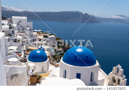 Scenic blue domes of Oia over Santorini volcanic caldera Greece Scenic blue domes of Oia over Santorini volcanic caldera Greece 141057601