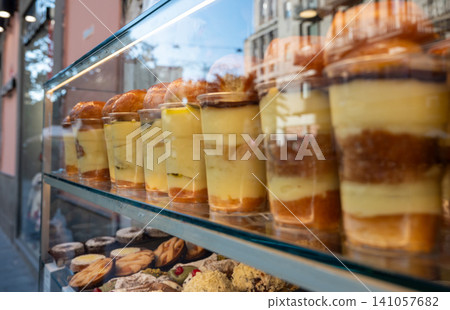 Naples, italy. December 27, 2024. Delicious rum babas and other italian pastries displayed in a bakery window, inviting passersby in spaccanapoli, naples Naples, italy. December 27, 2024. Delicious rum babas and other italian pastries displayed in a bakery window, inviting passersby in spaccanapoli, naples 141057682