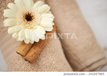 Detail, closeup and flower on towel in spa for luxury service in hospitality at hotel on holiday or vacation. Floral, cinnamon and offer object in accommodation for wellness treatment on table Detail, closeup and flower on towel in spa for luxury service in hospitality at hotel on holiday or vacation. Floral, cinnamon and offer object in accommodation for wellness treatment on table 141057965