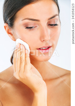 Face, woman and cotton pad for clean skin, makeup removal and skincare for beauty on white background. Product, healthy glow and routine for hygiene, wellness and self care with cosmetics in studio Face, woman and cotton pad for clean skin, makeup removal and skincare for beauty on white background. Product, healthy glow and routine for hygiene, wellness and self care with cosmetics in studio 141058123