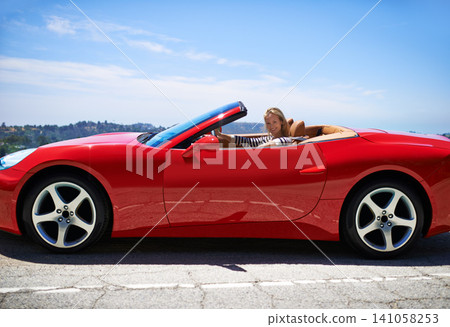 Woman, red sports car and road trip for holiday, travel and luxury transport on summer drive. Happy female person, convertible and countryside wellness on street, vacation and adventure in vehicle Woman, red sports car and road trip for holiday, travel and luxury transport on summer drive. Happy female person, convertible and countryside wellness on street, vacation and adventure in vehicle 141058253