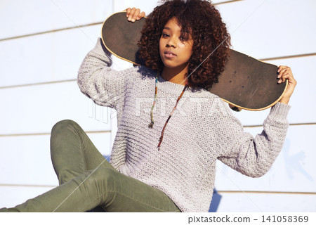 Portrait, confidence and woman with skateboard in city by wall in summer for sport, attitude or relax outdoor. Serious person, skate park and young girl in casual clothes for fashion in South Africa Portrait, confidence and woman with skateboard in city by wall in summer for sport, attitude or relax outdoor. Serious person, skate park and young girl in casual clothes for fashion in South Africa 141058369