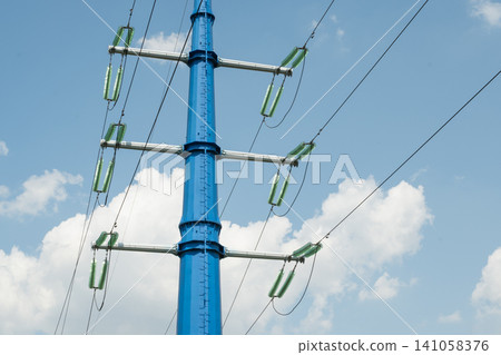 High voltage power line tower against blue sky High voltage power line tower against blue sky 141058376