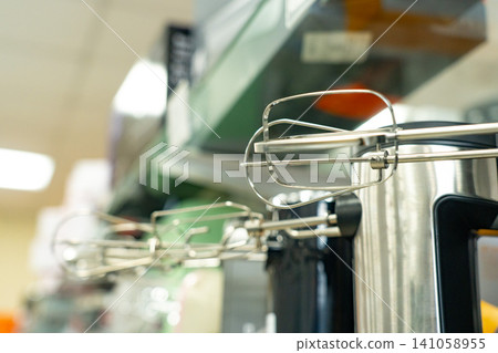 A Close-Up View of Hand Mixer Attachments Displayed on a Kitchen Shelf, Showcasing Their Sleek Design and Functionality for Mixing and Baking Tasks A Close-Up View of Hand Mixer Attachments Displayed on a Kitchen Shelf, Showcasing Their Sleek Design and Functionality for Mixing and Baking Tasks 141058955