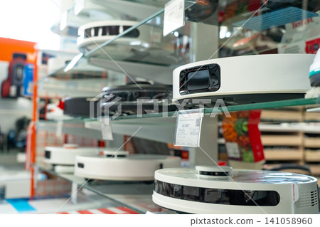 Exploring a Modern Selection of Robotic Vacuum Cleaners Displayed Neatly on Glass Shelves in an Innovative Home Appliance Store Exploring a Modern Selection of Robotic Vacuum Cleaners Displayed Neatly on Glass Shelves in an Innovative Home Appliance Store 141058960