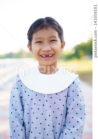 Portrait of Asian girl smiling at camera in nature outdoor. Portrait of Asian girl smiling at camera in nature outdoor. 141059101