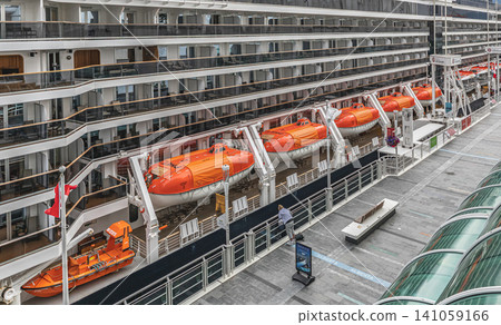 Large modern luxury cruise ship side view with lifeboats in the port of Vancouver Canada. Lifeboats displayed aboard a cruise ship, for safety and preparedness measures Travel photo July 10,2022 141059166