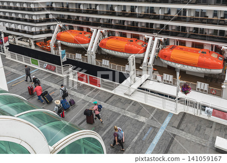 Large modern luxury cruise ship side view with lifeboats in the port of Vancouver Canada. Lifeboats displayed aboard a cruise ship, for safety and preparedness measures Travel photo July 10,2022 Large modern luxury cruise ship side view with lifeboats in the port of Vancouver Canada. Lifeboats displayed aboard a cruise ship, for safety and preparedness measures Travel photo July 10,2022 141059167
