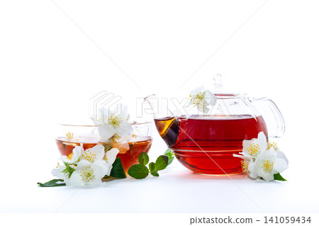 transparent cup with jasmine tea and jasmine flowers on white background transparent cup with jasmine tea and jasmine flowers on white background 141059434