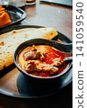 Indian Chicken Curry with Roti Flatbread and Toasted Bread on Wooden Table 141059540