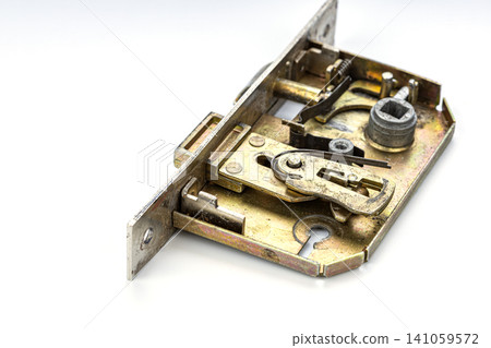 Close up of disassembled brass mortise door lock mechanism revealing intricate internal components including springs latches bolt tumblers and cylinder housing on white background 141059572