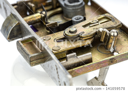 Detailed macro photograph of an old brass door lock mechanism revealing intricate internal components including metal gears springs levers and bolts showcasing precision engineering craftsmanship Detailed macro photograph of an old brass door lock mechanism revealing intricate internal components including metal gears springs levers and bolts showcasing precision engineering craftsmanship 141059578