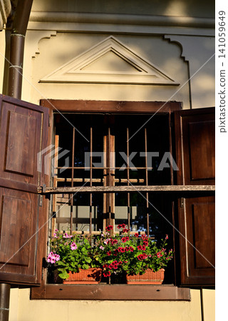 Open wooden window with flowers on old wall Open wooden window with flowers on old wall 141059649