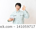 An Asian senior female worker makes an OK sign. 141059717