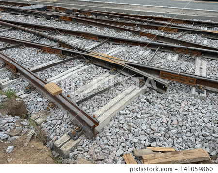 Railway switch with intersecting tracks, ballast, concrete sleepers and steel rails on modern rail infrastructure. Transportation, logistics, railway engineering, infrastructure, mobility, freight Railway switch with intersecting tracks, ballast, concrete sleepers and steel rails on modern rail infrastructure. Transportation, logistics, railway engineering, infrastructure, mobility, freight 141059860