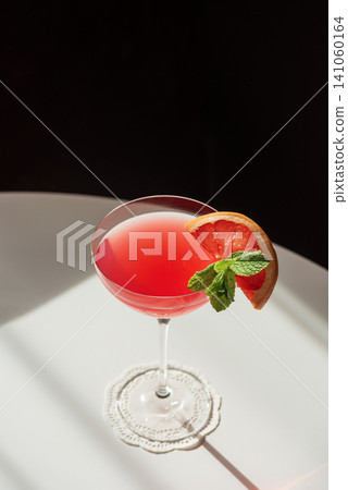 Pink grapefruit cocktail with mint in coupe glass Pink grapefruit cocktail with mint in coupe glass 141060164