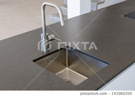 Modern kitchen island with a sleek stainless steel sink and faucet Modern kitchen island with a sleek stainless steel sink and faucet 141060209