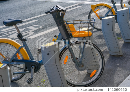 Bikes for rent parked in city street. Bicycle sharing service. Urban environment and alternative transportation. Public transport for vacation, infrastructure in Europe Bikes for rent parked in city street. Bicycle sharing service. Urban environment and alternative transportation. Public transport for vacation, infrastructure in Europe 141060630