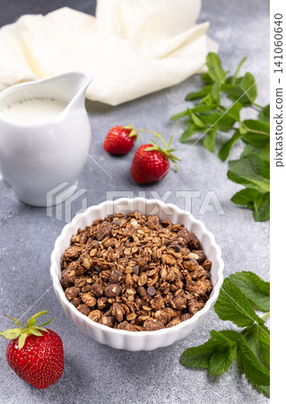 Chocolate granola bowl with fresh strawberries and milk jug Chocolate granola bowl with fresh strawberries and milk jug 141060640