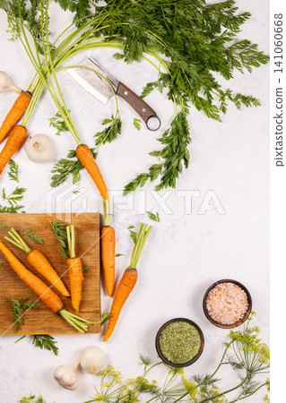 Carrots, garlic, spices, and cleaver on white background 141060668