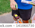 an orienteering athlete holding a map and wearing a green finger chip 141060730