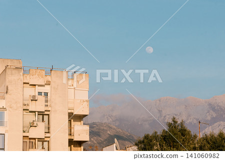 View full moon in sky day, panorama building on mountains Montenegro background View full moon in sky day, panorama building on mountains Montenegro background 141060982