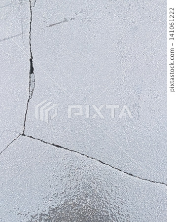 Cracked texture background on a white paved surface | Material representing aging and deterioration Cracked texture background on a white paved surface | Material representing aging and deterioration 141061222