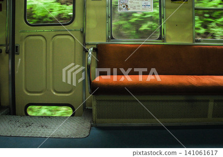 The retro interior of the Kominato Railway train, with the fresh greenery flowing past the window. The retro interior of the Kominato Railway train, with the fresh greenery flowing past the window. 141061617