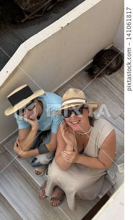 Women Relaxing on Staircase with Cat Nearby Women Relaxing on Staircase with Cat Nearby 141061817