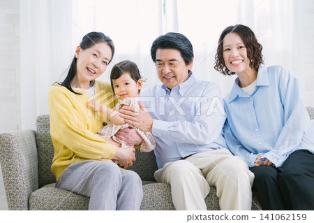 A portrait of a three-generation family relaxing in the living room. A portrait of a three-generation family relaxing in the living room. 141062159