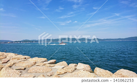 A high-speed passenger ship sailing on the calm Seto Inland Sea, against the backdrop of early summer scenery. A high-speed passenger ship sailing on the calm Seto Inland Sea, against the backdrop of early summer scenery. 141062253